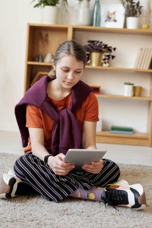 Photo of child sitting on the floor reading a book